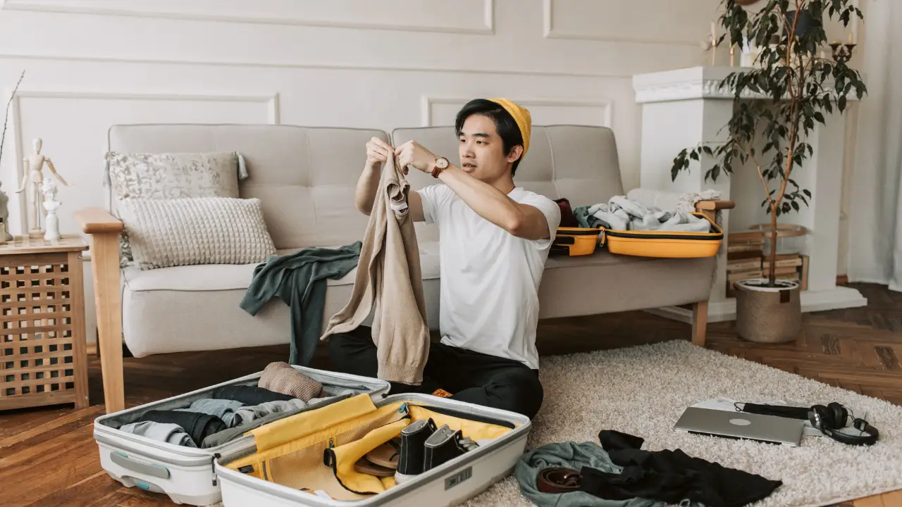 Person Packing a Suitcase with Healthy Snacks and Workout Gear